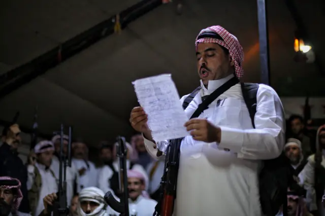 شيخ عشيرة يخاطب مجموعة من المسلحين المتجمعين داخل مقر مجلس القبائل والعشائر السورية في إدلب، سوريا، 18 يوليو/تموز 2025، خلال إعلان النفير العام دعماً للقبائل البدوية في السويداء.