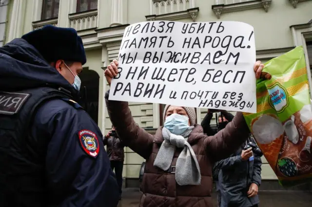 Женщина с плакатом и надписью "Нельзя убить память народа!"