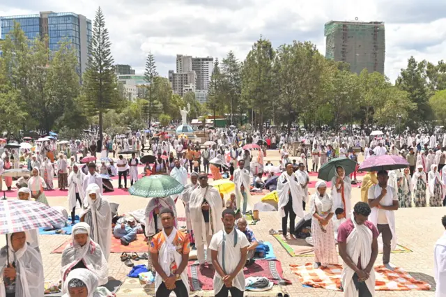 ኣብ ስግደት ዝርአ ብዙሕ ህዝቢ፡ ብድሕሪኡ ነዋሕቲ ህንጻታት ኣዲስ ኣበባን ኣግራብን ይርአ