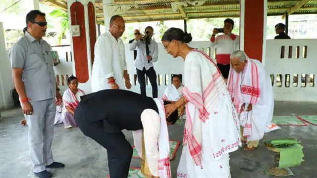 एक महिला का पैर छूते सर्बानंद सोनोवाल