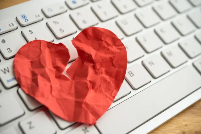 Un corazon de papel roto sobre un teclado