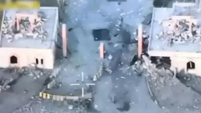 تصویری که با استفاده از کمره یک پهپاد ورودی کالج نظامی را نشان می‌دهد. دو طرف دو ساختمان دیده می‌شوند که بخش‌شهایی از آنها تخریب شده است.