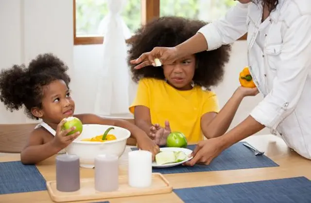 Une femme interagissant avec ses fillespendant petit-déjeuner