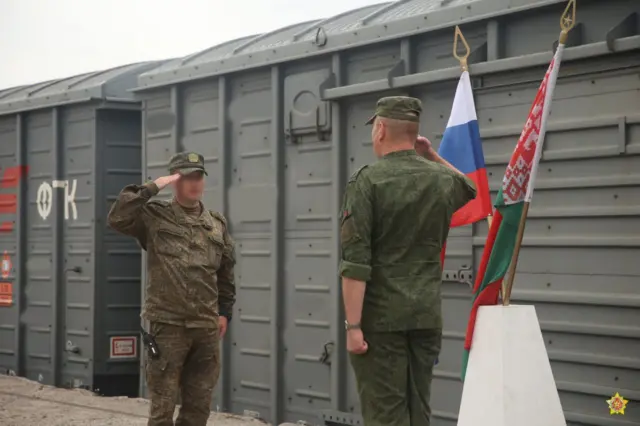 Двоє військових біля прапорів РФ та Білорусі