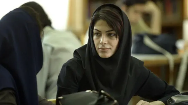 Женщина с покрытой головой сидит на занятиях