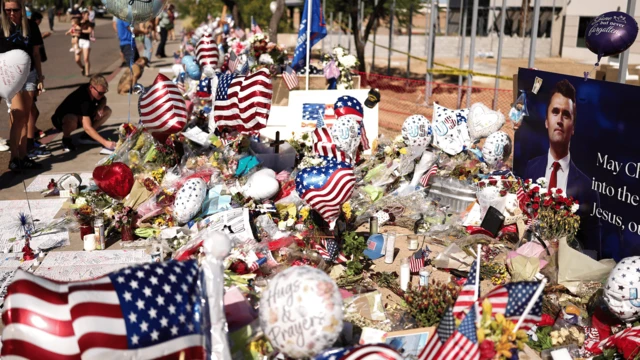 Charlie Kirk suikastı ardından Phoenix, Arizona'da oluşturulmuş bir anma köşesi, Kirk'ün fotoğrafı, Amerikan bayrakları ve çiçeklerle kaplı bir alan