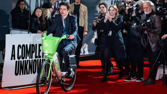 Chalamet no tapete vermelho da estreia de 'Um Completo Desconhecido' em Londres em uma das características bicicletas de aluguel de cor verde-limão da capital britânica.

