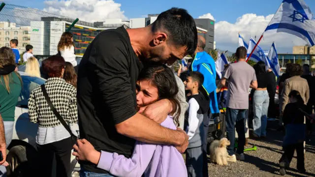 Otac teši svoju ćerku nakon što je prvi helikopter stigao sa taocima u bolnicu Belinson u Izraelu.
