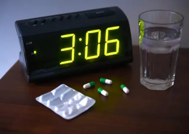 Une horloge, un verre d'eau et des médicaments