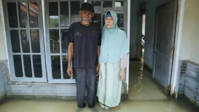 Suwandi e a mulher, Watini, na varanda de sua casa alagada em Blok Empang, Eretan Wetan, Indramayu