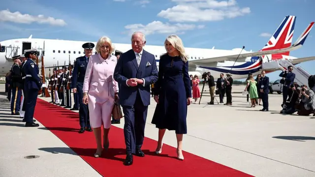 Король Карл III и королева Камилла идут по красной дорожке