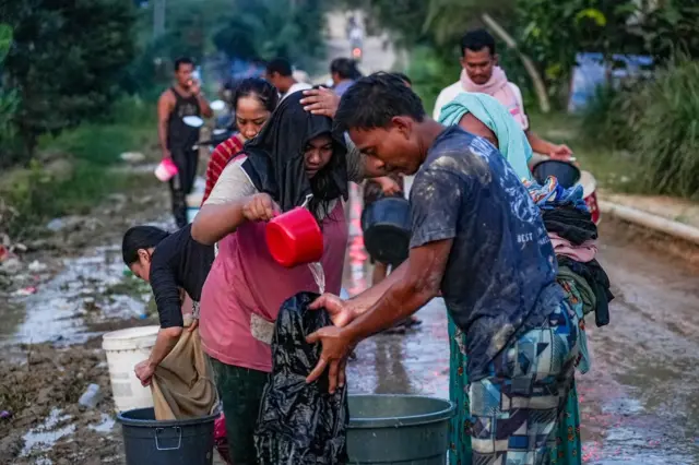 Sejumlah warga menggunakan air parit untuk mencuci pakaian di Rantau, Kabupaten Aceh Tamiang, Aceh, Jumat (5/12/2025).