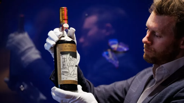 Homem exibe uísque Macallan 1926