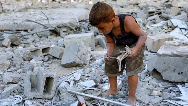 Un niño busca trozos de madera entre los escombros de la torre Salam, otro de los edificios detonados en la Ciudad de Gaza.