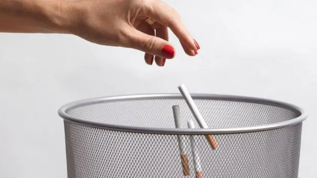 सिगारेट कचर्यात फेकून देणारा हात