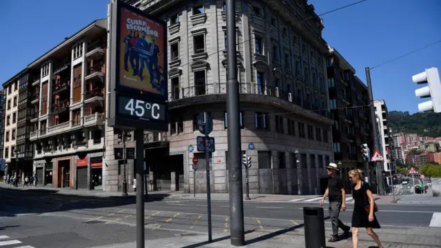 Para przechodzi obok ulicznego termometru wskazującego 45 stopni Celsjusza.