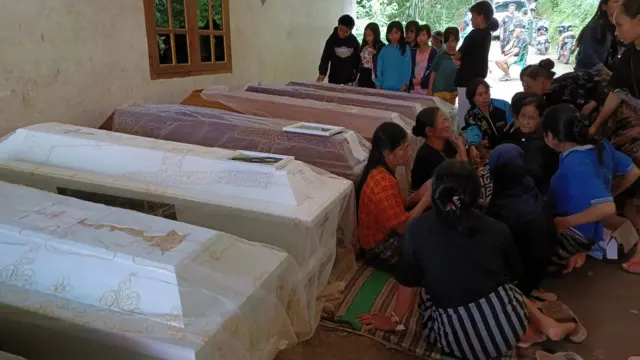 Kerabat dan warga meratap di sekeliling peti mati yang mengandung jenazah korban tanah longsor yang terjadi di Tana Toraja, Sulawesi Selatan.