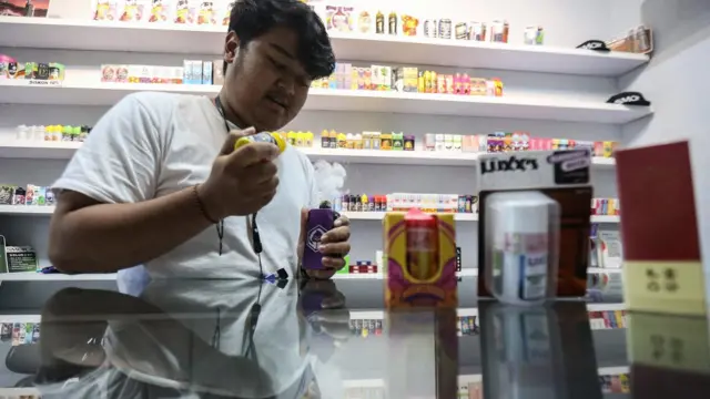Penjual meneteskan cairan pada rokok elektrik di salah satu toko di Pekayon, Jakarta Timur, Selasa (27/12/2022). 