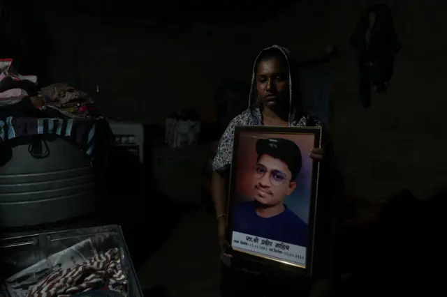 Babita Kumari, sister of Pradeep Kumar, 22, an aspirant doctor who took his own life after the results of the first NEET exam were cancelled, poses for a picture as she holds a photo of her brother at her home in Jhunjhunu, India, July 21, 2026. REUTERS/Francis Mascarenhas