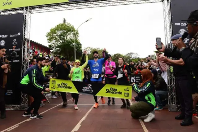 Hugo cruzando la meta de la maratón 366 junto a su familia.