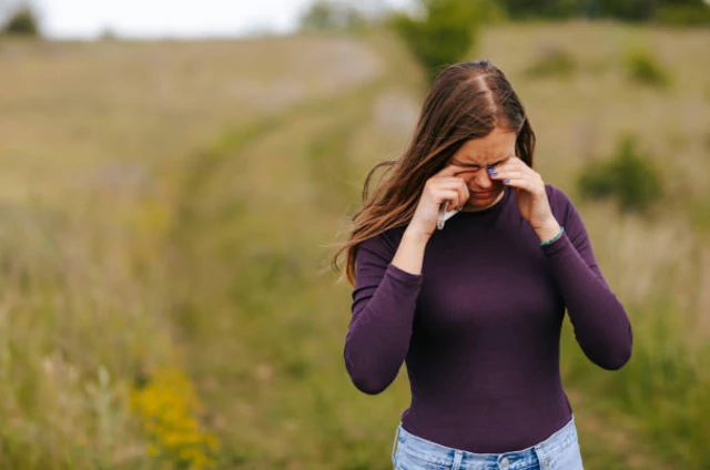 รูปผู้หญิงยืนร้องไห้กลางทุ่ง