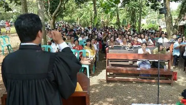 Pendeta Kristen Indonesia Torang Simanjuntak menyampaikan misa Minggu Paskah di samping reruntuhan Gereja Kristen Protestan Batak Taman Sari di Bekasi, di pinggiran Jakarta pada tanggal 31 Maret 2013. 