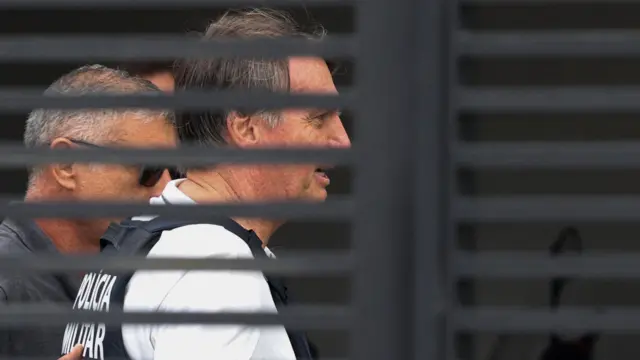 O ex-presidente brasileiro Jair Bolsonaro chega em casa para começar a cumprir prisão domiciliar em 27 de março de 2026