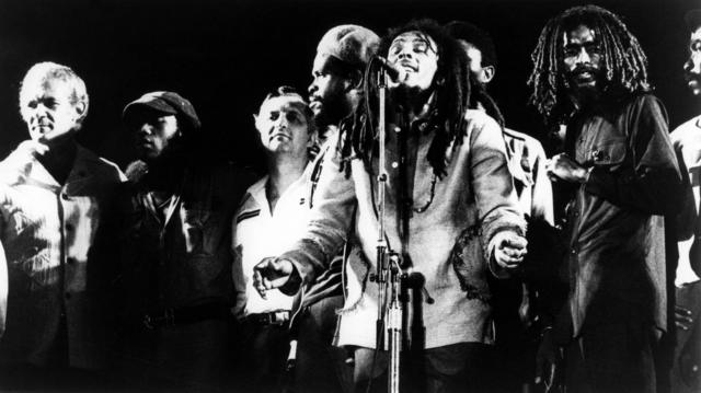 Bob Marley sur scène avec plusieurs autres personnes, dont le Premier ministre jamaïcain Michael Manley