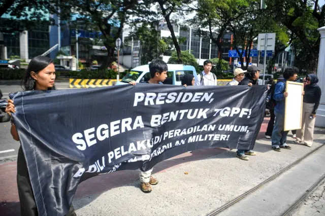 Sejumlah pimpinan organisasi masyarakat sipil yang tergabung dalam Koalisi Solidaritas untuk Andrie Yunus membentangkan spanduk dan menunjukkan surat yang akan diberikan kepada Presiden Prabowo di halaman Kantor Kementerian Sekretariat Negara, Jakarta, Jumat (17/4/2026).