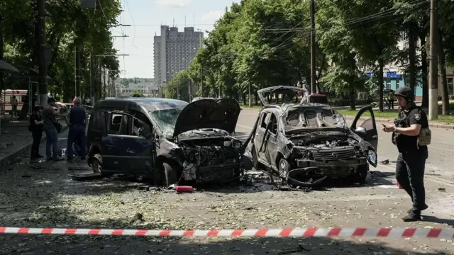 Россия наращивает наступление на Сумскую область. Что о нем известно и есть ли угроза областному центру? 5 За полицейской лентой стоят две поврежденные при обстреле машины.