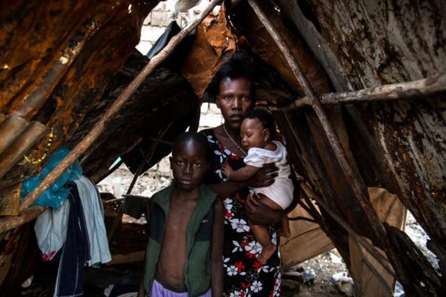 Una madre con dos hijos en Haití.