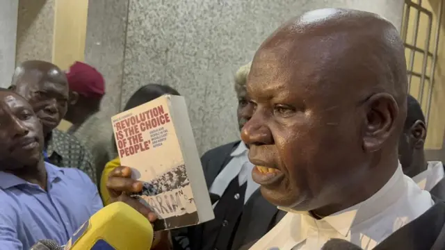 Simon Lough, wey be senior advocate of Nigeria dey display book wey police seize for Andrew Wynne bookshop wey dem tok say e dey incite pipo to mutiny.