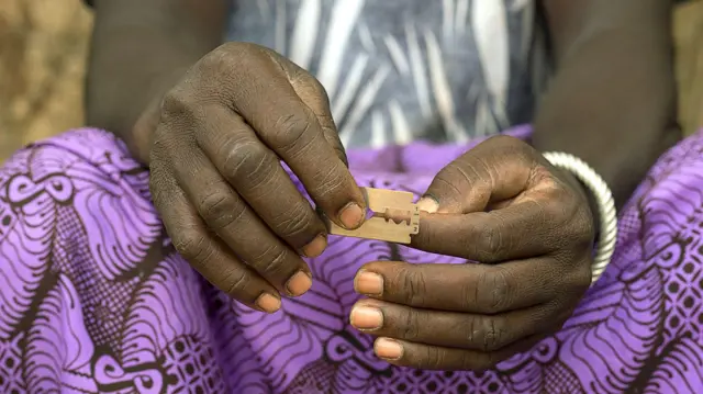 Uma mulher segurando uma lâmina