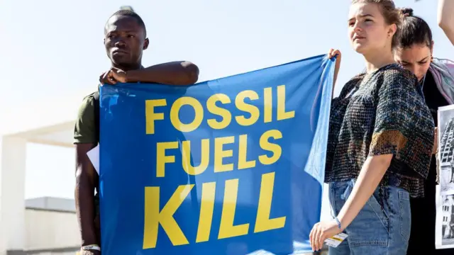 Para kaum muda mengunjuk rasa untuk menentang penggunaan bahan bakar fosil di depan Konferensi Perubahan Iklim PBB COP27 yang diselenggarakan oleh UNFCCC di Mesir