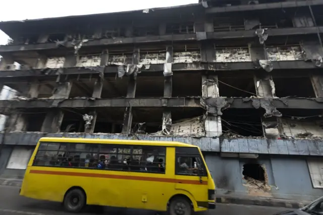 जेन जी आन्दोलनका क्रममा जलाइएको भाटभटेनी सूपरमार्केटको भवनअगाडि सडकमा गुडिरहेको पहेँलो रङ्गको बस