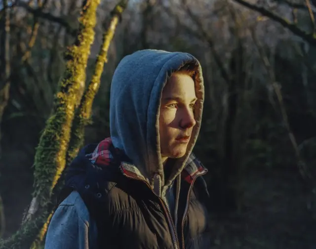 A teenage boy in the woods