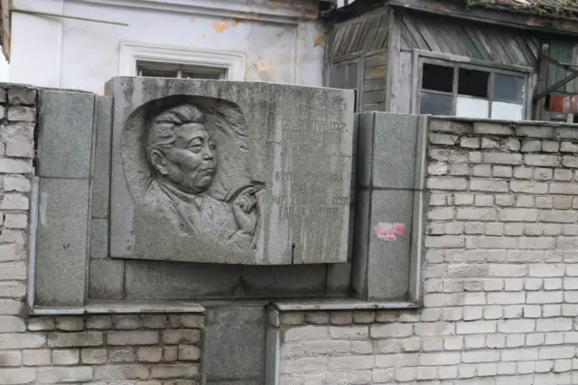 Азыр көрсөңөр, бул үйдүн сыртына илинген мемориалдык тактадагы сүрөттөр дагы өчүп баратыптыр. Үйдүн өзү каралбай калган.