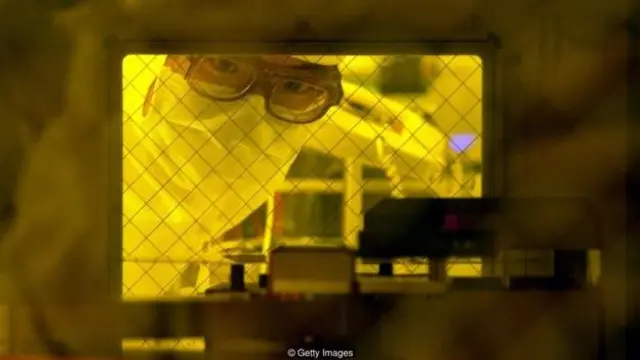 Seorang teknisi memeriksa wafer 12 inci di ruang bebas debu di pabrik UMC di Tainan, sebelum nantinya dipotong menjadi cip mikro.