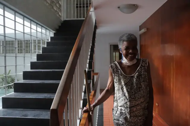 María en la escalera del edificio en el que trabaja.