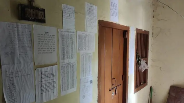 திட்டங்களின் பெயர்கள் காகிதங்களில் அலுவலக அறையின் வெளிப்புற சுவரில் ஒட்டப்பட்டுள்ளன.