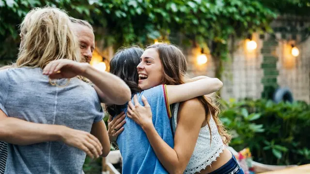 Personas salundándose y abrazándose