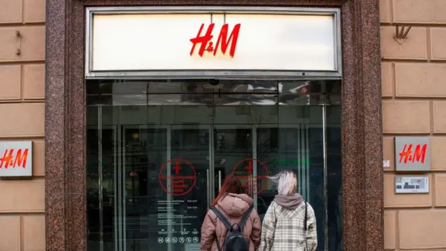 মস্কোতে বন্ধ হয়ে যাওয়া এইচ এ্যান্ড এম দোকানের সামনে দুইজন তরুণী।