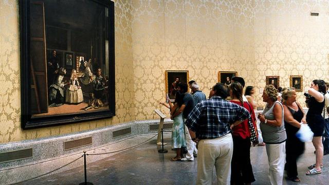 Visitantes mirando "Las Meninas" en el Museo del Prado.