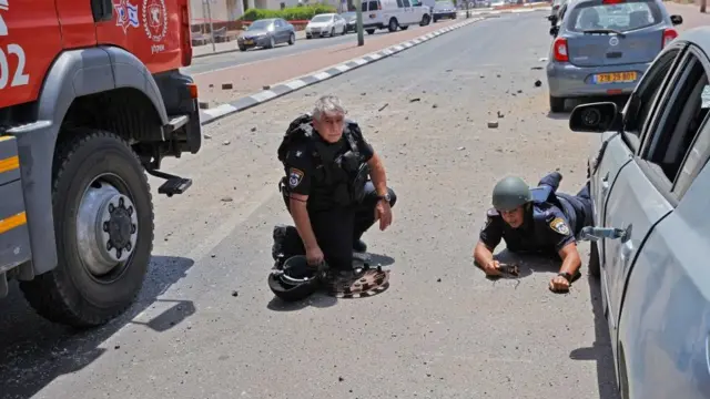 গাযা থেকে রকেট ছোড়া শুরু হলে আত্মরক্ষার জন্য ইসরায়েলের অশকেলন শহরে রাস্তায় শুয়ে পড়েছে কয়েকজন সৈন্য