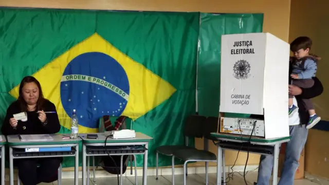 Homem vota com criança no colo