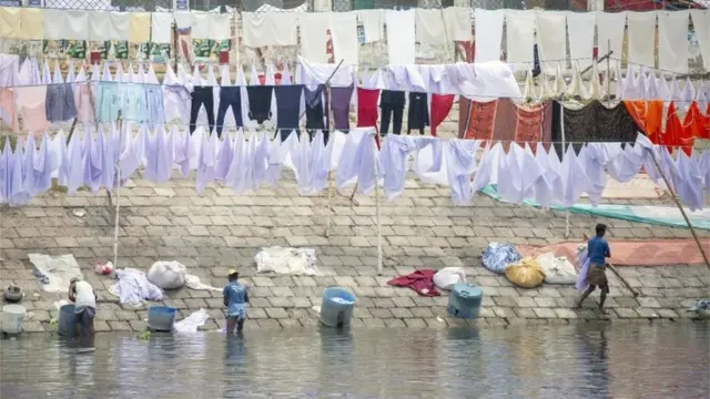 बांग्लादेश में कपड़े साफ़ करते धोबी