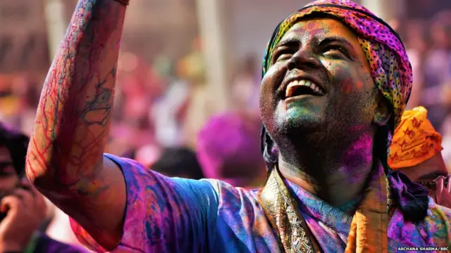 रंगों से सराबोर होली खेलने की खुशी जाहिर करता एक युवक