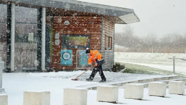 мужчина убирает снег