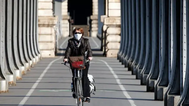 A woman cycles in Paris