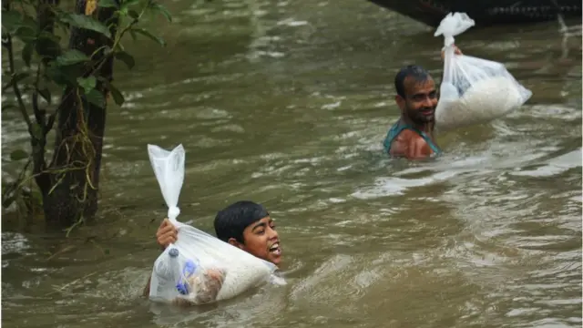 ত্রাণ নিতে বুক সমান পানি সাঁতরে এসেছেন বানভাসী মানুষ।